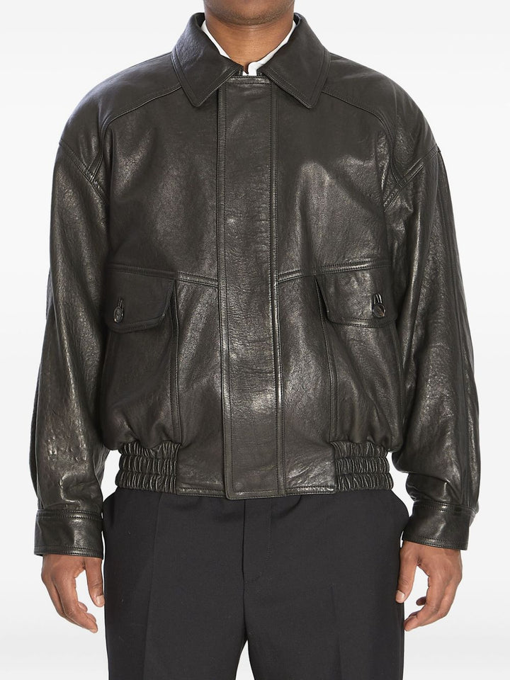 Bomber con zip nascosta, collo a punta, spalle scese e vita arricciata.