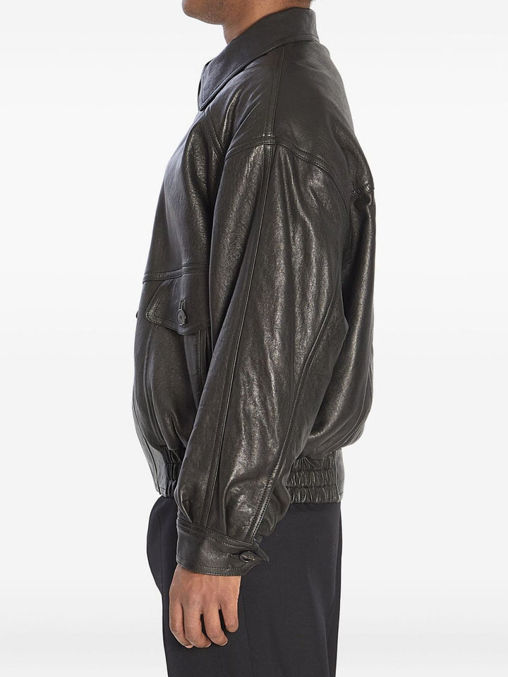 Bomber con zip nascosta, collo a punta, spalle scese e vita arricciata.