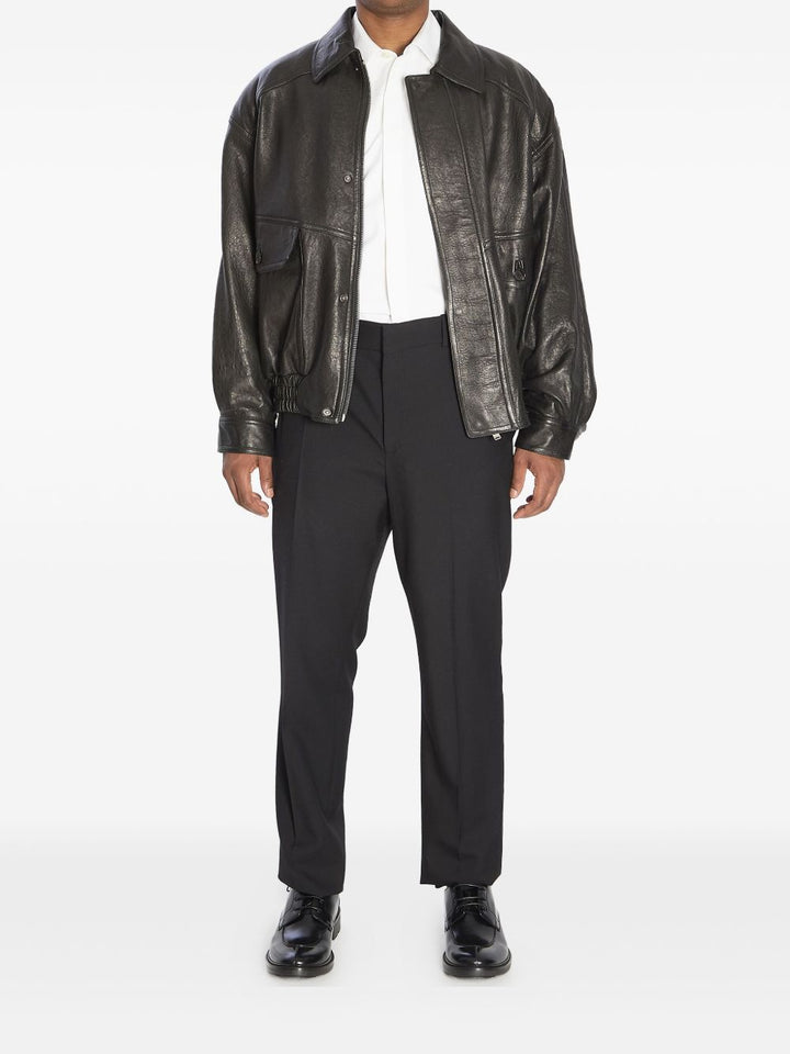 Bomber con zip nascosta, collo a punta, spalle scese e vita arricciata.